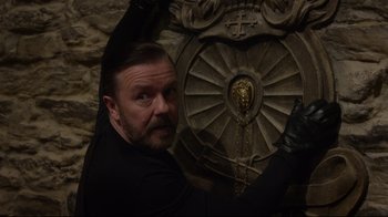 Movie still from “Muppets Most Wanted” (2014), directed by James Bobin – A man with a goatee is leaning against a wall; Close Up shot, High angle
