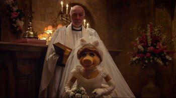 Movie still from “Muppets Most Wanted” (2014), directed by James Bobin – A man standing next to a woman in a wedding dress; Medium shot, Over the shoulder angle