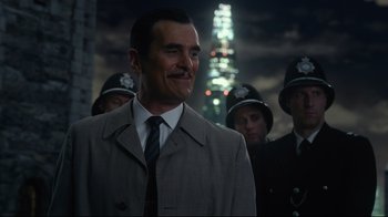 Movie still from “Muppets Most Wanted” (2014), directed by James Bobin – A group of men standing next to each other in front of a tall building; Close Up shot, Over the shoulder angle