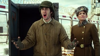 Movie still from “Muppets Most Wanted” (2014), directed by James Bobin – A man wearing a brown jacket and a green hat singing; Medium shot, Low angle