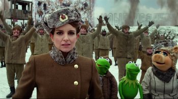 Movie still from “Muppets Most Wanted” (2014), directed by James Bobin – A woman in a military uniform with a group of people in the background; Medium shot, Over the shoulder angle