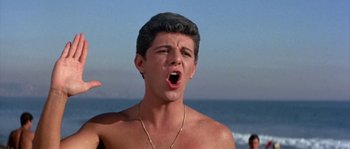 Movie still from “Muscle Beach Party” (1964), directed by William Asher – A young man with his mouth wide open; Close Up shot, Low angle
