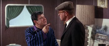 Movie still from “Muscle Beach Party” (1964), directed by William Asher – Two men are talking to each other in a room; Medium shot, Over the shoulder angle