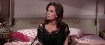 Movie still from “Muscle Beach Party” (1964), directed by William Asher – A woman wearing a black dress sitting on a bed; Medium shot, High angle