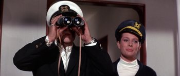 Movie still from “Muscle Beach Party” (1964), directed by William Asher – A man and a woman in uniform looking through binoculars; Medium shot, Low angle