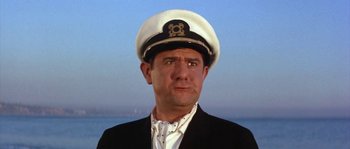 Movie still from “Muscle Beach Party” (1964), directed by William Asher – A man wearing a white hat and a black suit; Close Up shot, Low angle