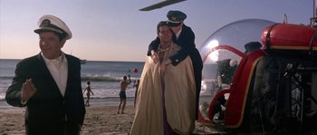 Movie still from “Muscle Beach Party” (1964), directed by William Asher – A man and a woman are hugging on the beach; Wide shot, Low angle