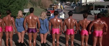 Movie still from “Muscle Beach Party” (1964), directed by William Asher – A group of men and women in their underwear walking down a street; Wide shot, Over the shoulder angle