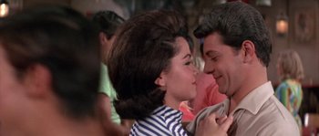 Movie still from “Muscle Beach Party” (1964), directed by William Asher – A man and a woman are kissing in a crowd; Close Up shot, Low angle