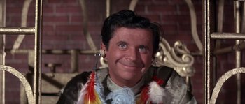 Movie still from “Muscle Beach Party” (1964), directed by William Asher – A person wearing feathers around their neck; Close Up shot, Low angle