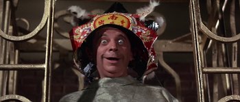 Movie still from “Muscle Beach Party” (1964), directed by William Asher – A man wearing a chinese hat and looking surprised; Close Up shot, Low angle