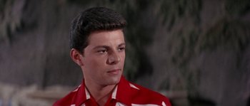 Movie still from “Muscle Beach Party” (1964), directed by William Asher – A man in a red and white striped shirt looks to his left; Close Up shot, Low angle
