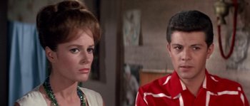 Movie still from “Muscle Beach Party” (1964), directed by William Asher – A man and a woman are standing next to each other; Close Up shot, Low angle