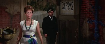 Movie still from “Muscle Beach Party” (1964), directed by William Asher – A man and a woman walking down a street; Medium shot, Over the shoulder angle