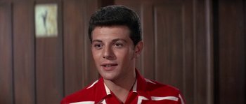 Movie still from “Muscle Beach Party” (1964), directed by William Asher – A man in a red and white striped shirt looks to his left; Close Up shot, Low angle