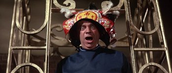 Movie still from “Muscle Beach Party” (1964), directed by William Asher – A man wearing a chinese hat with a surprised look on his face; Close Up shot, Low angle