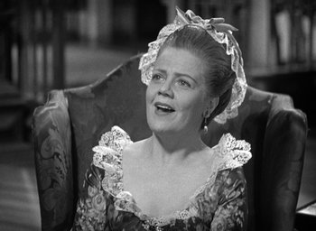 Movie still from “Mutiny on the Bounty” (1935), directed by Frank Lloyd – An older woman wearing a dress with a bow in her hair; Close Up shot, Low angle