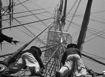 Movie still from “Mutiny on the Bounty” (1935), directed by Frank Lloyd – Two men are climbing up the side of a tall ship; Wide shot, Low angle