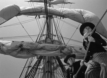 Movie still from “Mutiny on the Bounty” (1935), directed by Frank Lloyd – Two men are standing on a boat in the water; Wide shot, Low angle