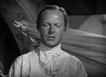 Movie still from “Mutiny on the Bounty” (1935), directed by Frank Lloyd – A man in a white shirt and a white bow tie; Close Up shot, Low angle