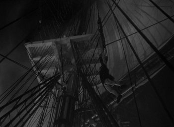 Movie still from “Mutiny on the Bounty” (1935), directed by Frank Lloyd – A man hanging from a rope on top of a tall ship; Extreme Wide shot, Overhead angle