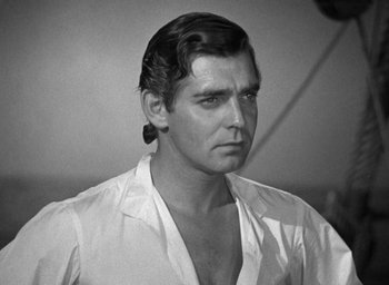 Movie still from “Mutiny on the Bounty” (1935), directed by Frank Lloyd – Black and white photograph of a man in a white shirt; Close Up shot, Over the shoulder angle