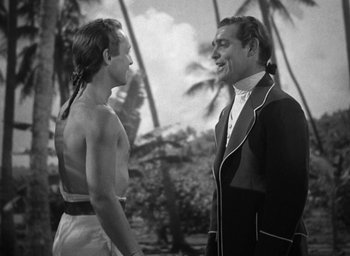 Movie still from “Mutiny on the Bounty” (1935), directed by Frank Lloyd – A man and a woman standing next to each other in front of palm trees; Medium shot, Over the shoulder angle