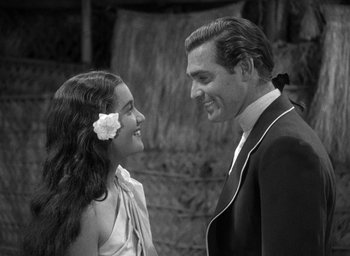 Movie still from “Mutiny on the Bounty” (1935), directed by Frank Lloyd – A man and a woman smiling at each other; Medium shot, Over the shoulder angle