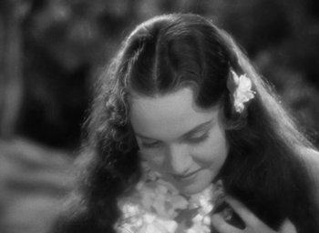 Movie still from “Mutiny on the Bounty” (1935), directed by Frank Lloyd – A woman with long dark hair wearing a flower lei; Close Up shot, High angle