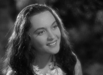 Movie still from “Mutiny on the Bounty” (1935), directed by Frank Lloyd – Black and white photograph of a young woman smiling for the camera; Close Up shot, High angle
