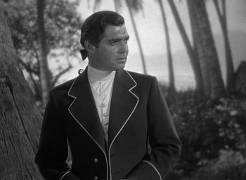 Movie still from “Mutiny on the Bounty” (1935), directed by Frank Lloyd – Black and white photograph of a man in a suit; Medium shot, Low angle