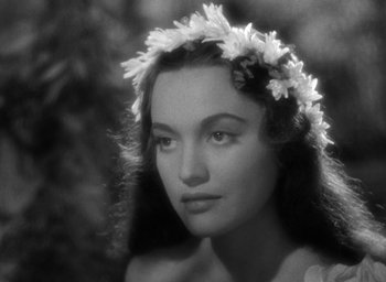 Movie still from “Mutiny on the Bounty” (1935), directed by Frank Lloyd – A black and white photo of a woman wearing a flower crown; Close Up shot, Over the shoulder angle