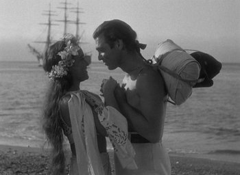 Movie still from “Mutiny on the Bounty” (1935), directed by Frank Lloyd – A man and a woman standing next to each other on the beach; Medium shot, High angle