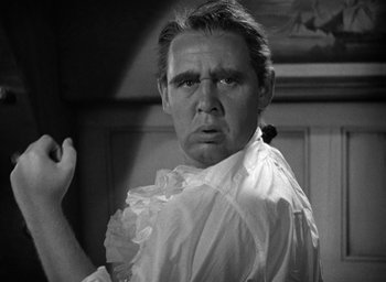 Movie still from “Mutiny on the Bounty” (1935), directed by Frank Lloyd – A black and white photo of a man in a white shirt; Close Up shot, Low angle