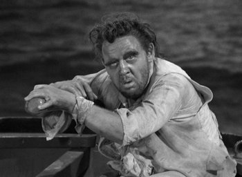 Movie still from “Mutiny on the Bounty” (1935), directed by Frank Lloyd – A man sitting on top of a boat in the water; Medium shot, High angle
