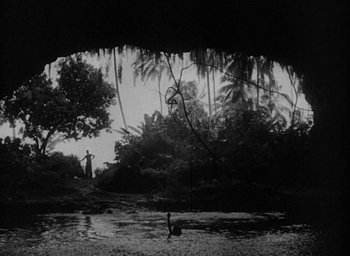 Movie still from “Mutiny on the Bounty” (1935), directed by Frank Lloyd – A person standing in a river near a forest; Extreme Wide shot, Low angle