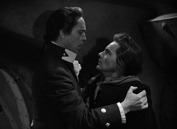 Movie still from “Mutiny on the Bounty” (1935), directed by Frank Lloyd – A man and a woman embracing each other in a black and white photo; Medium shot, Low angle