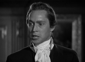 Movie still from “Mutiny on the Bounty” (1935), directed by Frank Lloyd – A black and white photo of a man in a suit and tie; Close Up shot, Low angle
