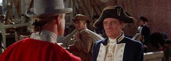 Movie still from “Mutiny on the Bounty” (1962), directed by George Seaton – A man in a hat is looking at another man in a hat; Medium shot, Over the shoulder angle