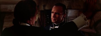 Movie still from “Mutiny on the Bounty” (1962), directed by George Seaton – A person wearing a suit and tie; Close Up shot, Over the shoulder angle