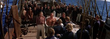 Movie still from “Mutiny on the Bounty” (1962), directed by George Seaton – A group of people standing on top of a boat; Wide shot, Over the shoulder angle