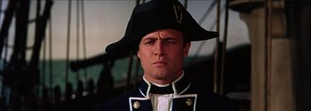 Movie still from “Mutiny on the Bounty” (1962), directed by George Seaton – A person wearing a uniform and wearing a hat; Close Up shot, Low angle