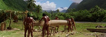 Movie still from “Mutiny on the Bounty” (1962), directed by George Seaton – A group of men working in a field with trees in the background; Extreme Wide shot, High angle