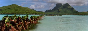 Movie still from “Mutiny on the Bounty” (1962), directed by George Seaton – A group of people in the water holding plants in their hands; Extreme Wide shot, High angle