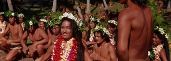 Movie still from “Mutiny on the Bounty” (1962), directed by George Seaton – A group of young people in a crowd wearing flower garlands; Medium shot, High angle