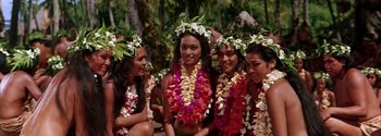 Movie still from “Mutiny on the Bounty” (1962), directed by George Seaton – A group of young women wearing flower leis; Medium shot, High angle