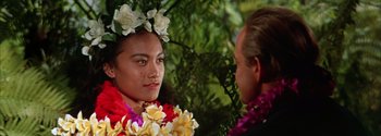 Movie still from “Mutiny on the Bounty” (1962), directed by George Seaton – A man and a woman wearing flower leis; Close Up shot, Over the shoulder angle