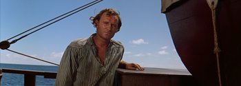 Movie still from “Mutiny on the Bounty” (1962), directed by George Seaton – A man leaning on a railing on a boat; Close Up shot, Low angle