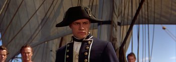 Movie still from “Mutiny on the Bounty” (1962), directed by George Seaton – A person wearing a uniform and a hat; Medium shot, High angle