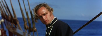 Movie still from “Mutiny on the Bounty” (1962), directed by George Seaton – A person with long hair; Close Up shot, Low angle